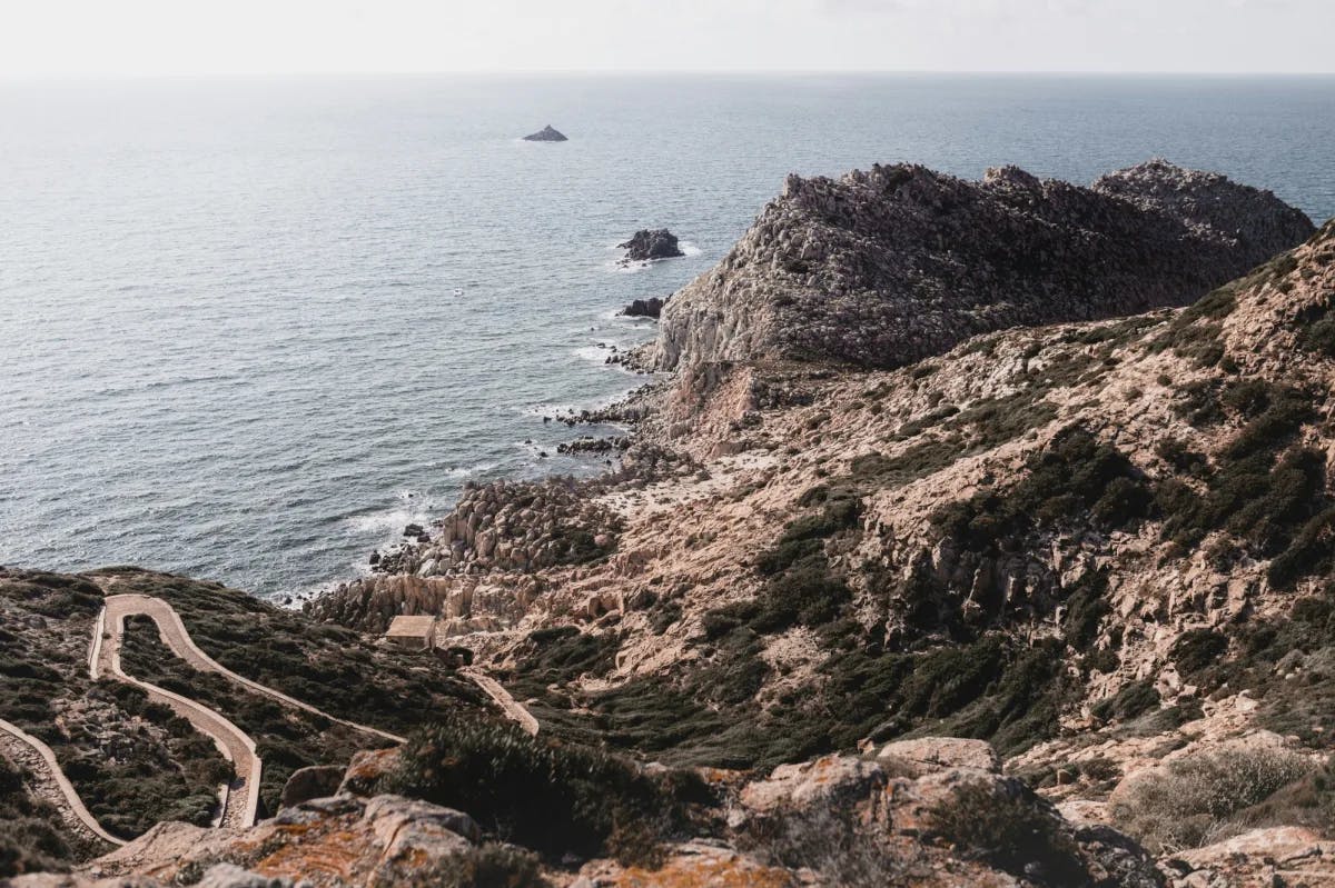 Ocean near rocky shore with a winding road.