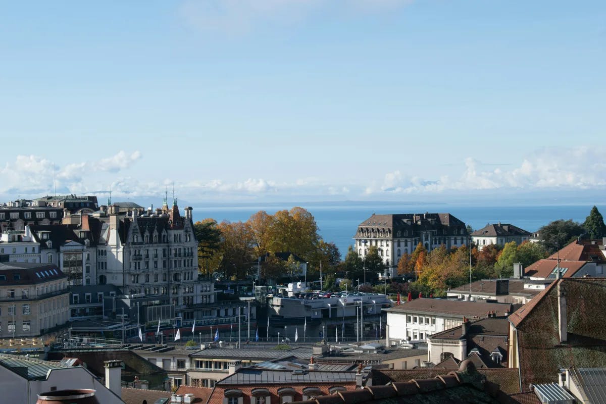 During the daytime, an aerial view of the city buildings, including the Lausanne Cathedral.