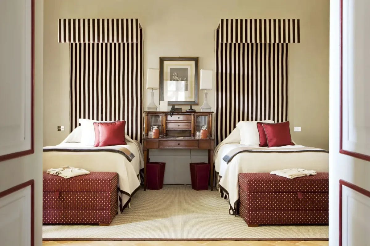 two twin beds flanked by black-and-white striped canopies