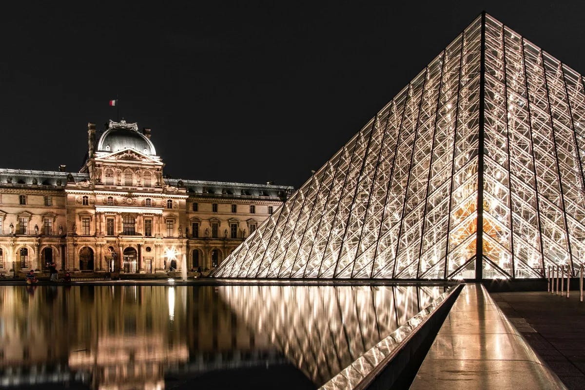 The exterior of the Louvre lit up at night.