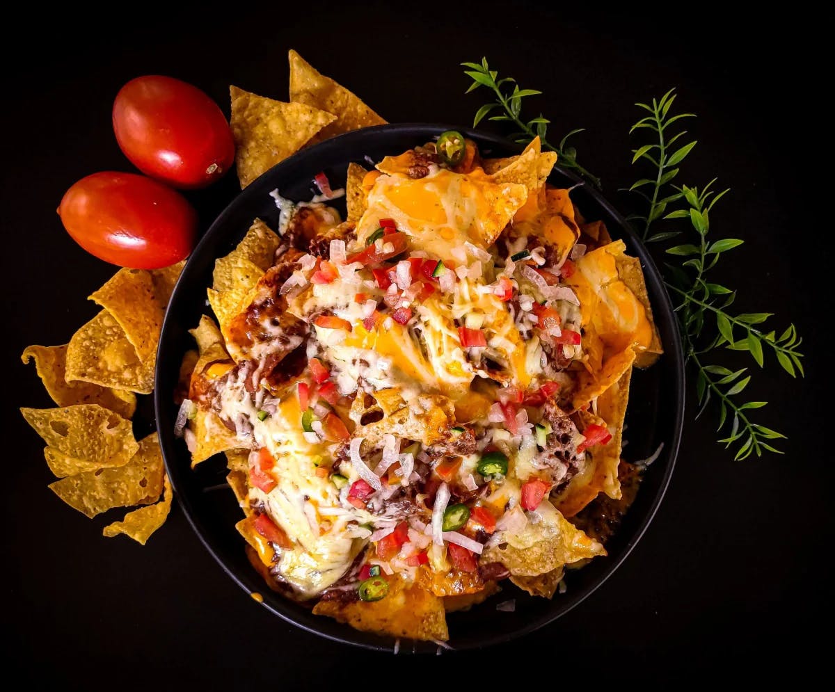 Nachos in a black bowl.