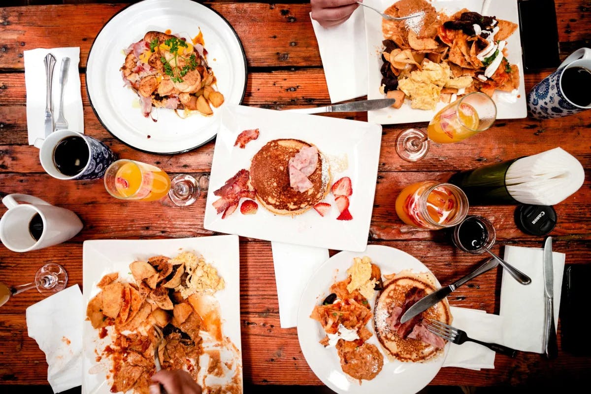  A variety of dishes served on white places at a restaurant.