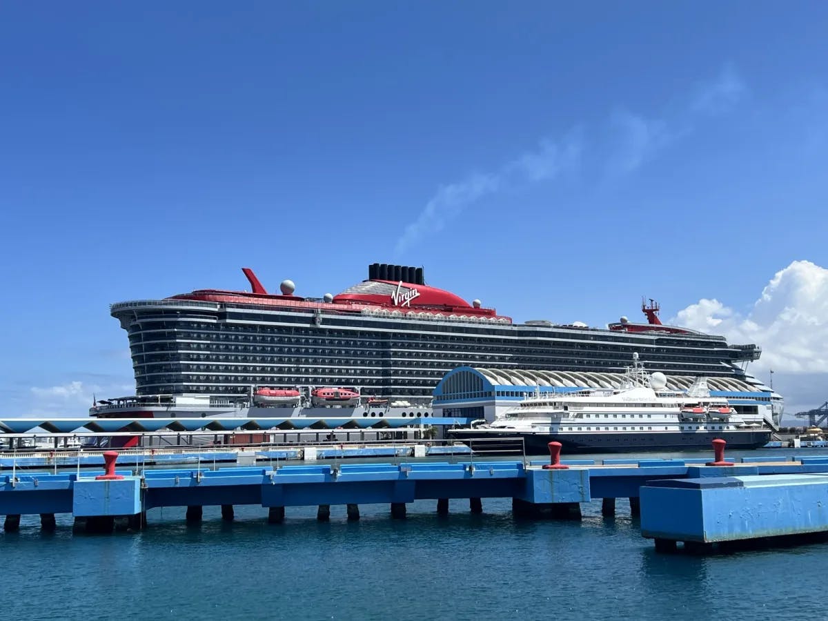 A cruise ship docked at the port on a sunny day. 