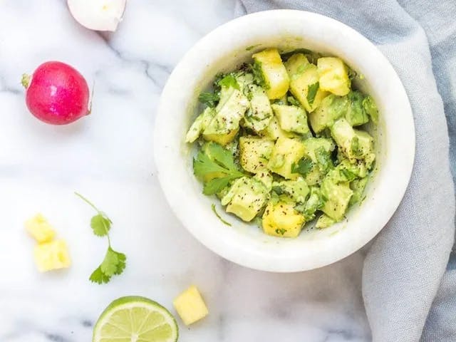  a tortilla into a bowl of guacamole