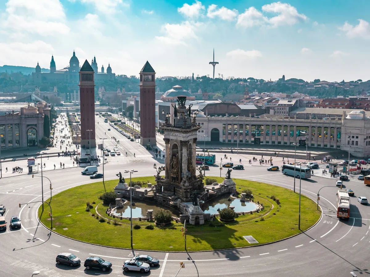 A panoramic cityscape with twin towers and a central monument, captured under a clear sky.