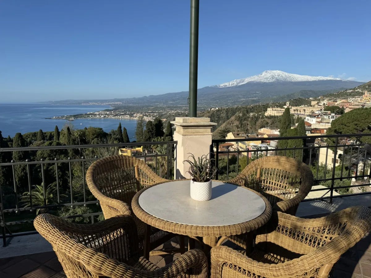 Balcony with chairs with city and ocean view.