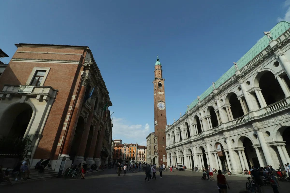 An open square, Piazza dei Signori in Vicenza, showcasing the town's architecture, clock tower and people out and about.