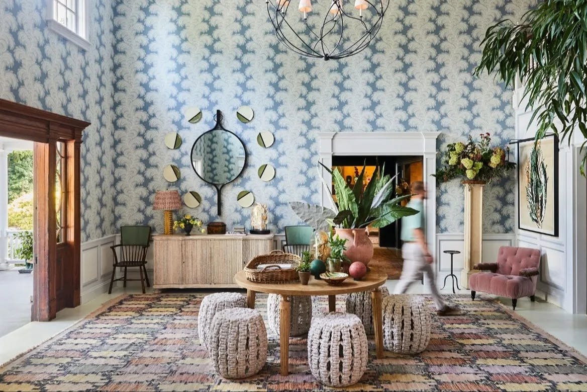 colorful blue and white lobby with colorful rug and multiple round mirrors