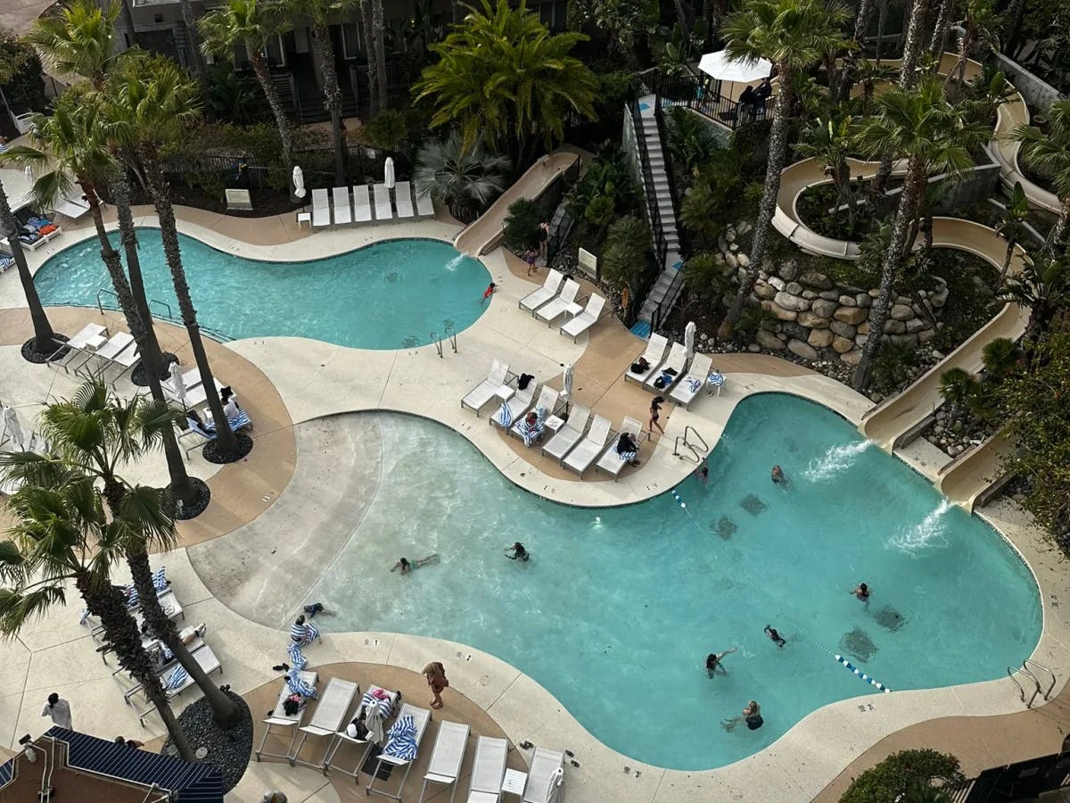 An aerial view of a hotel poolside during daytime.