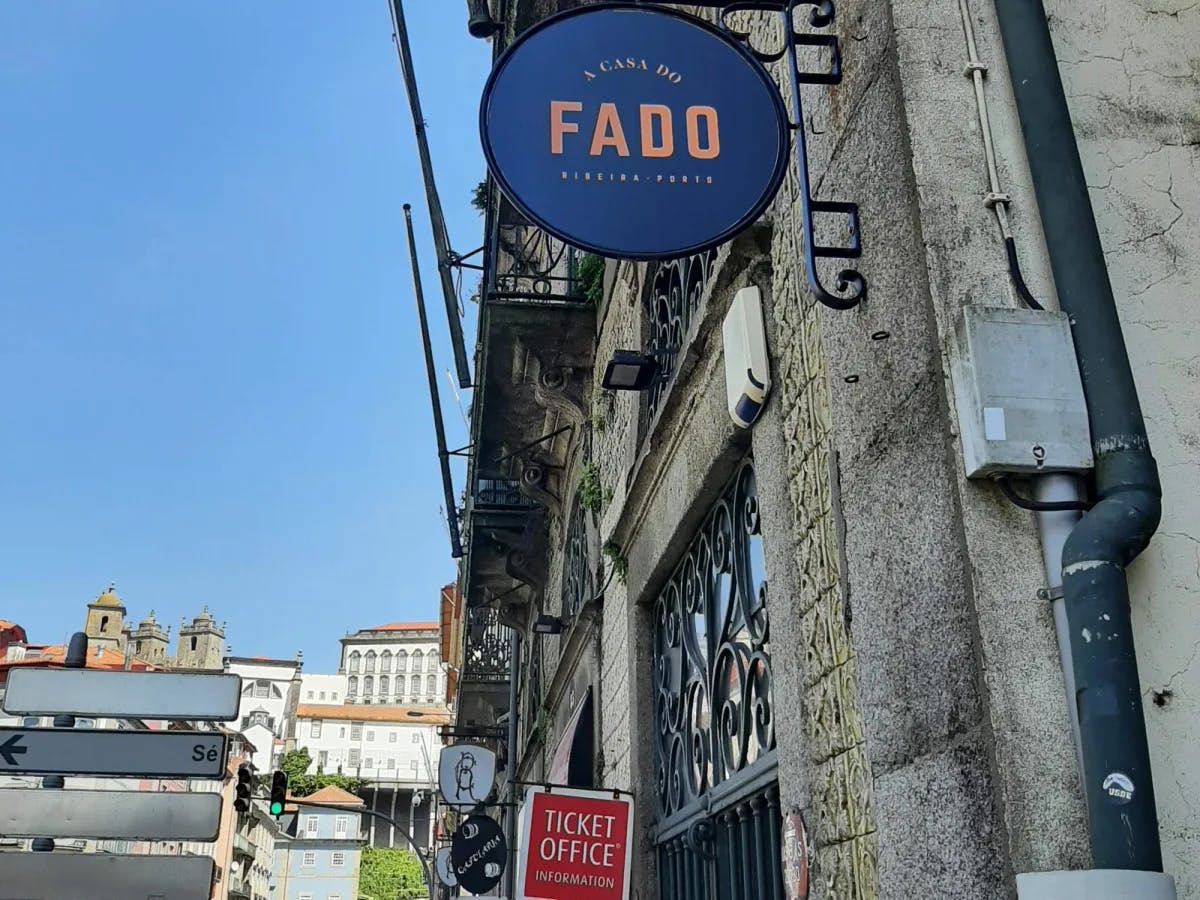 A city street with a sign on a building reading "Fado"