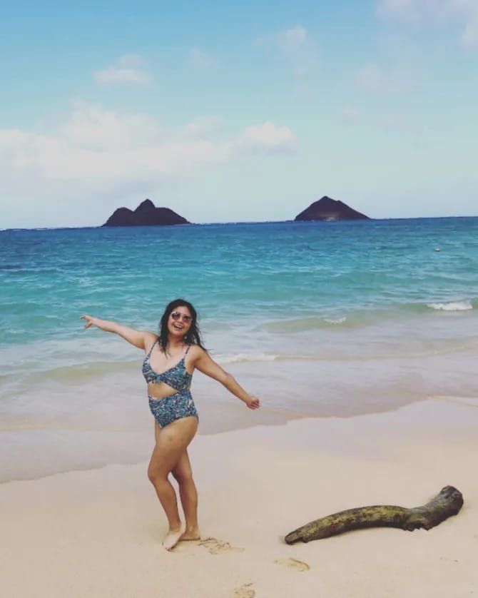 Claudine on a beach with a beautiful view.
