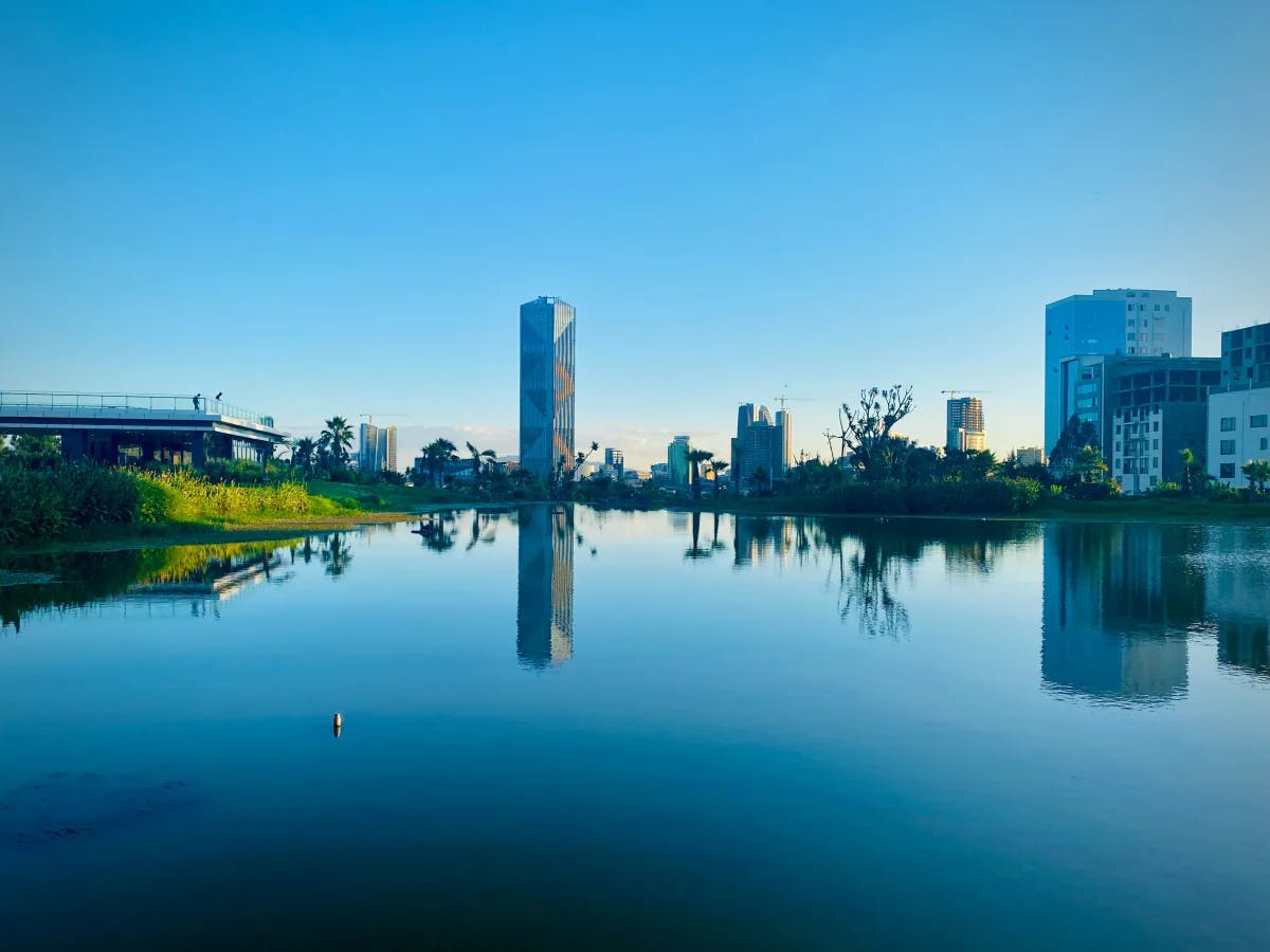 Friendship Park in Addis Ababa, with a large body of water next to city buildings.