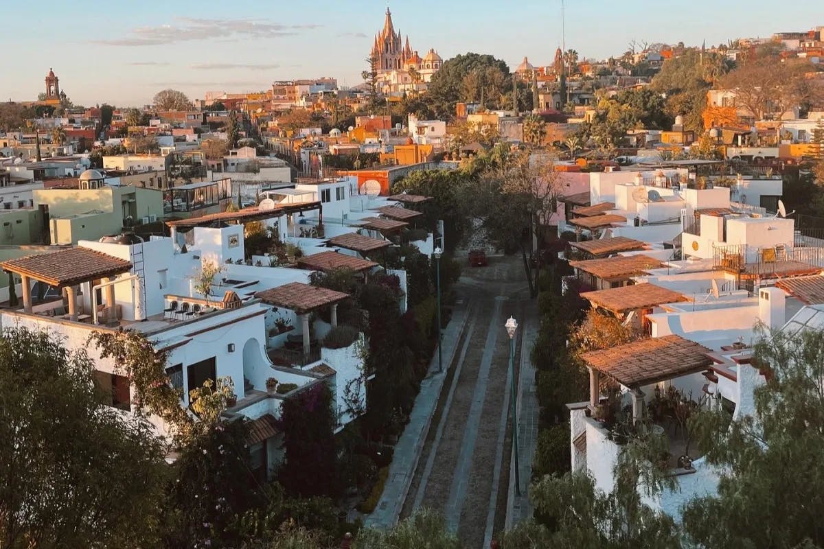 A rooftop view of city streets and houses at sunset from the Rosewood Luna Rooftop Tapas Bar.