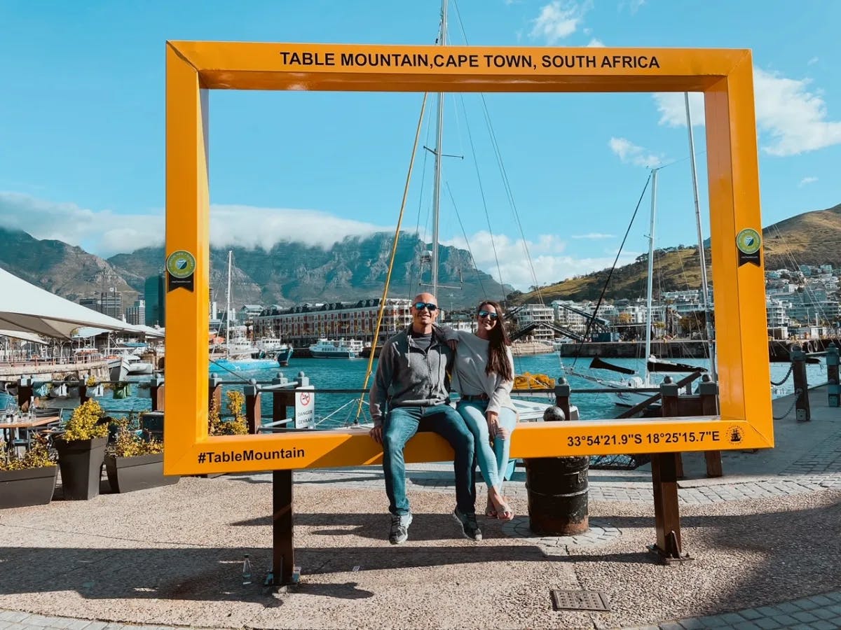 A couple sitting in front of a waterbody. 