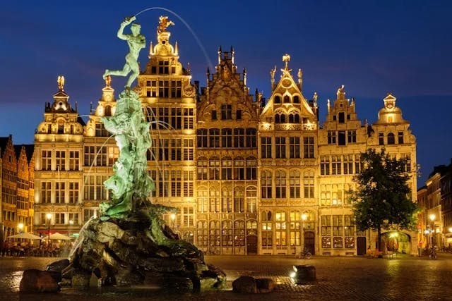 The Brabo Statue / Fountain in front of Antwerp's city hall building, and lit up at night. 