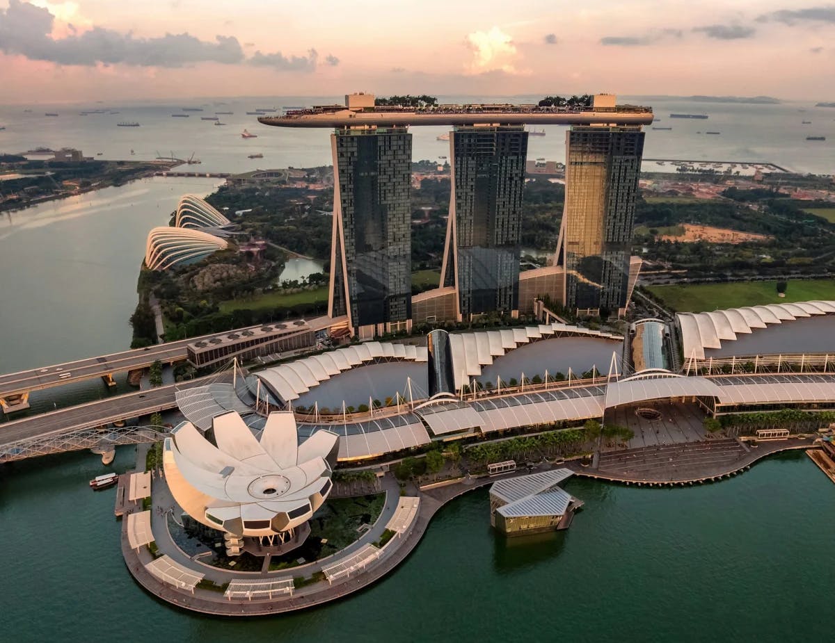 A sunset behind city buildings by the water