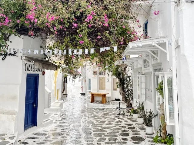 A cobblestone street lined with white buildings