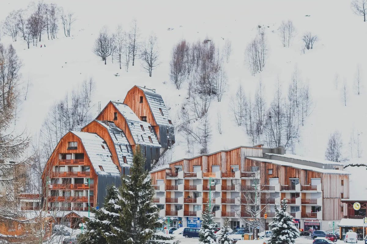 A picture of a resort covered in snow during daytime.