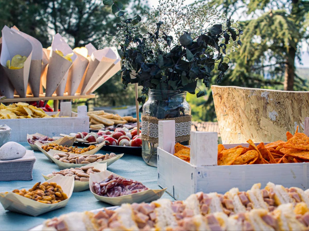 An array of food spread out on a table outside during the daytime