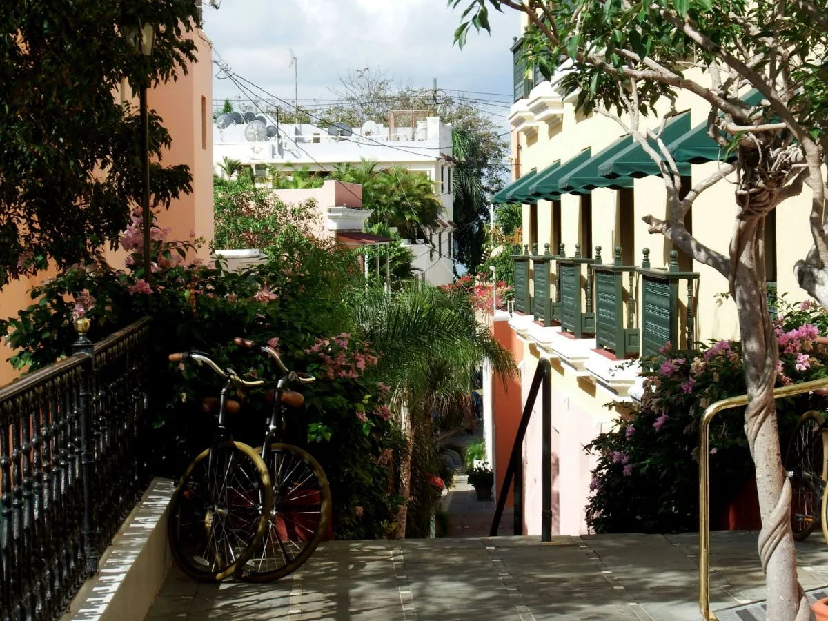 Bicycles parked in front of hotel with green railing.