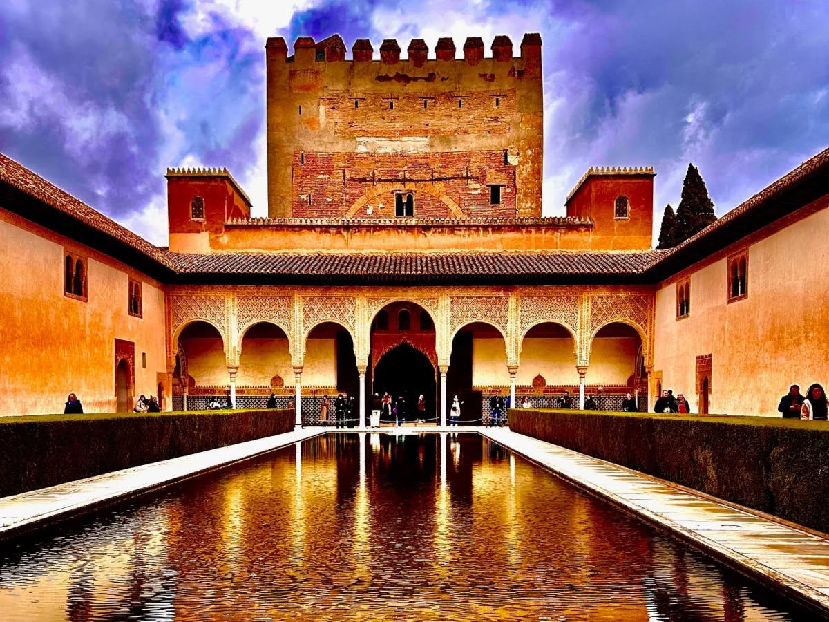 Brown building with a body of water at front.