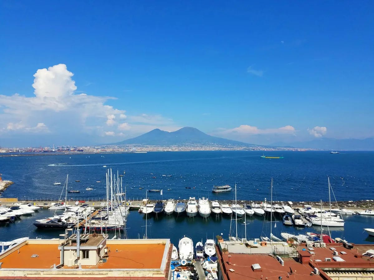 Naples Port – boats in the harbor with a volcano in the distance