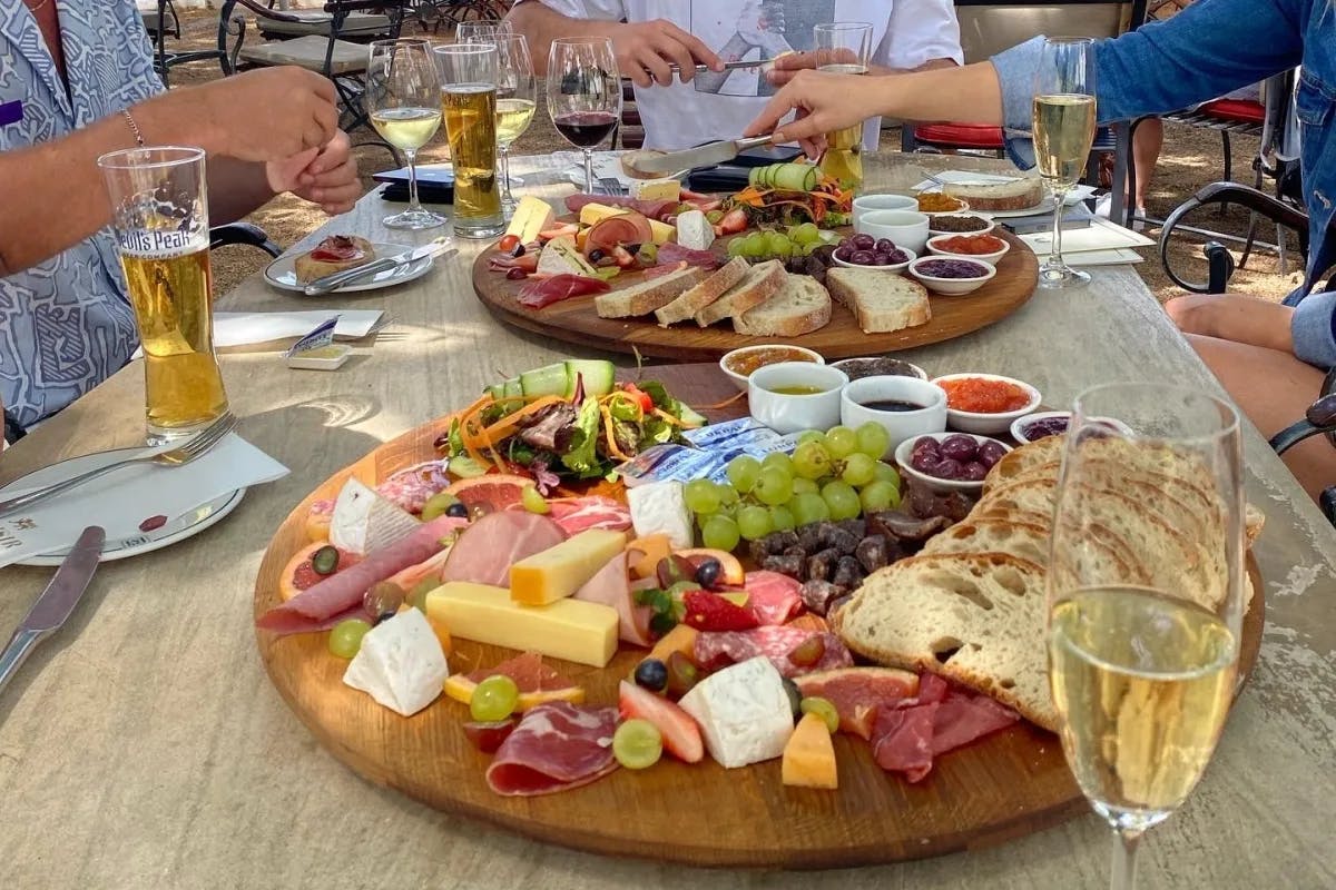 Food platter on a table with plates and drinks.