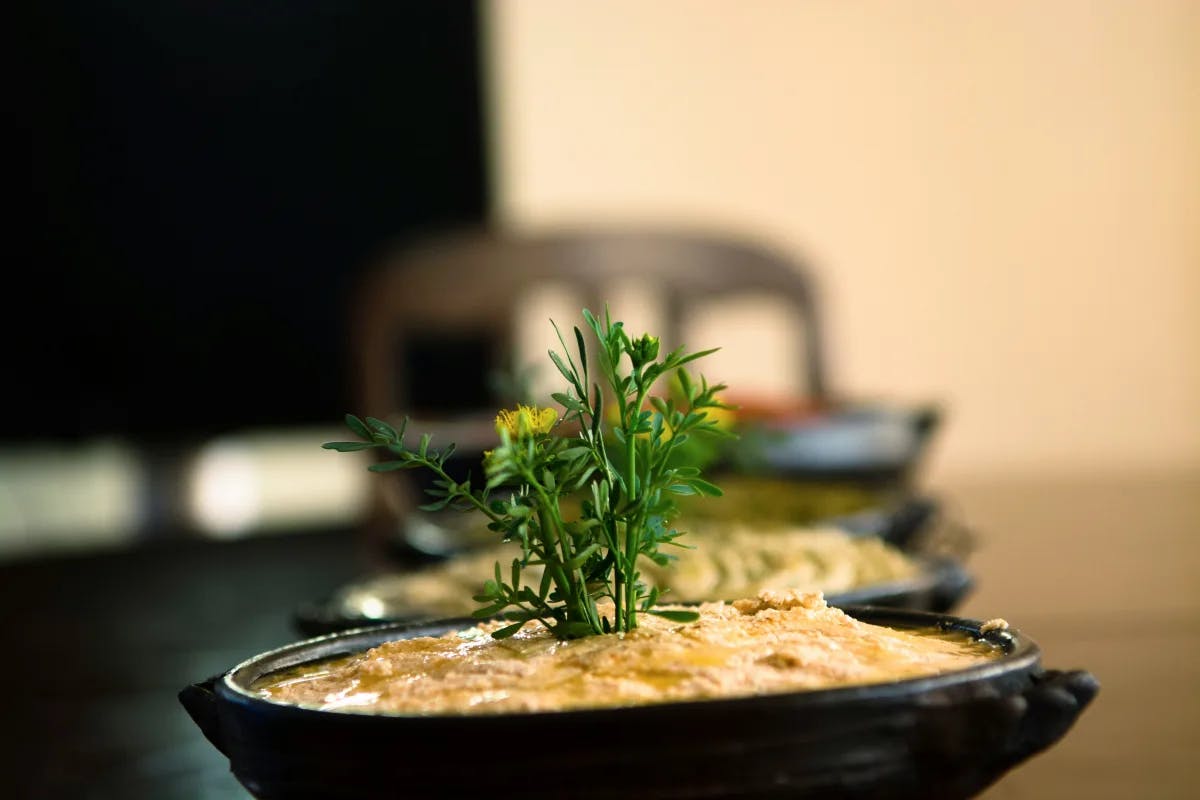 Ethiopian food with green garnish in a black bowl on a table.