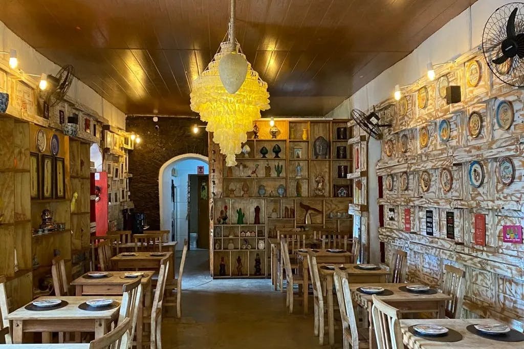 An interior view of marble walls, large chandeliers and avant-garde style designs inside of the Restaurante Cacimba Bistrô. 