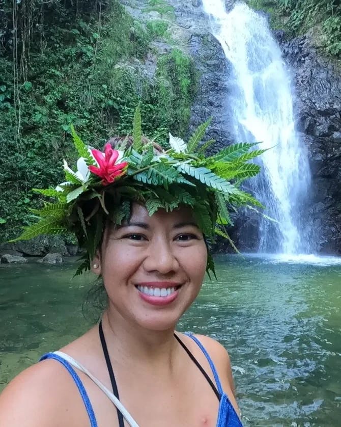 Travel advisor posing beside a waterfall