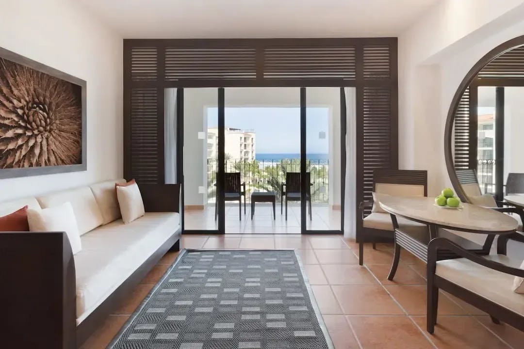 beachy furniture fills a common space that leads out to a balcony in a suite at Hyatt Ziva Los Cabos