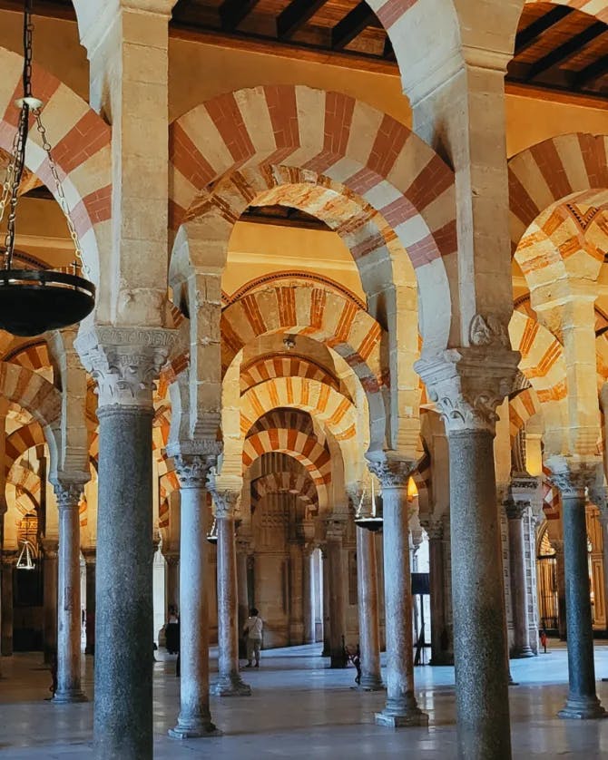 Inside architecture of a building with high arches and striped walls
