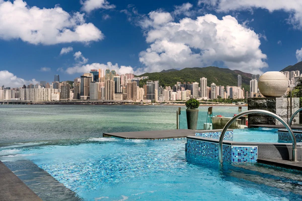 an infinity pool overlooking an urban harbor