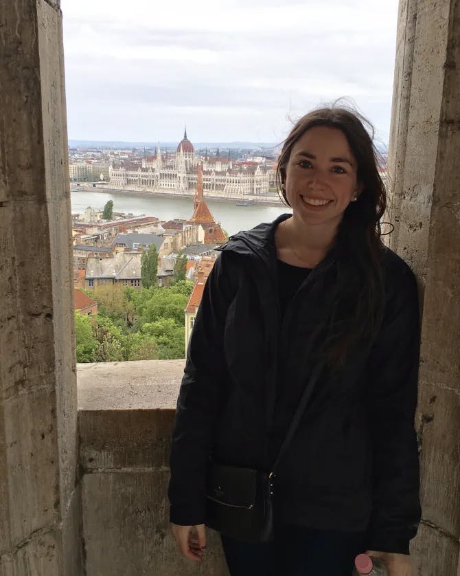 Picture of Lindsey standing infront of window with a view of Hungarian Parliament Building