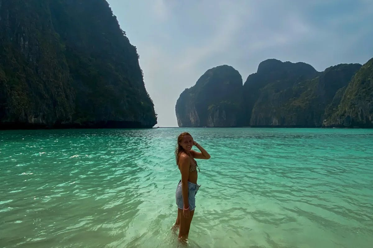 Isabel standing in water with rock formations in the background at Maya Bay.