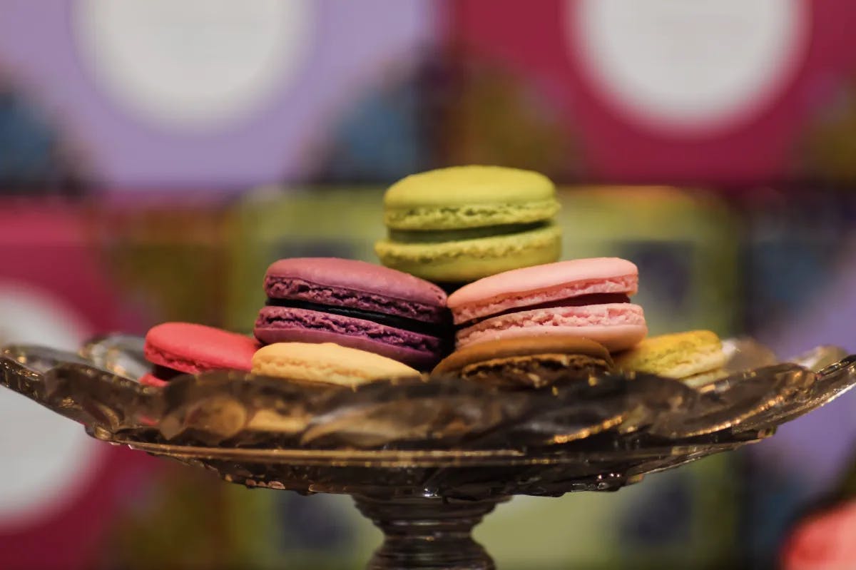 A golden tray holding colorful macarons. 
