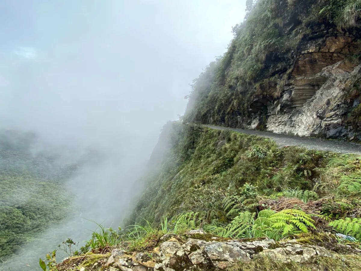 An aerial view of a cliffside road during the daytime.