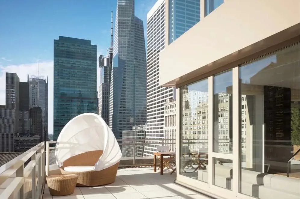 terrace with a shaded daybed overlooking a city skyline