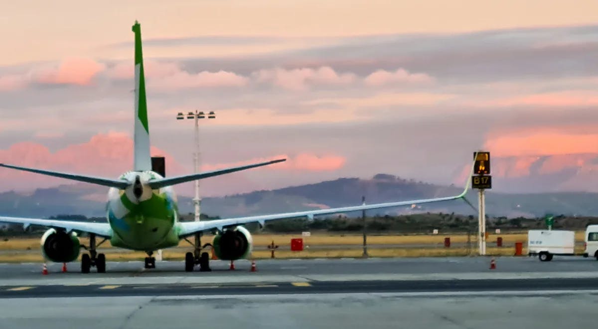 CPT airport with a plane landing during a beautiful sunset with the mountains in the distance 