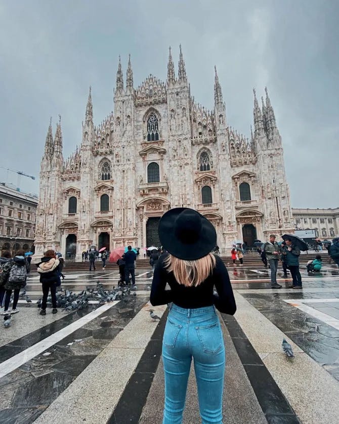 Advisor posing with a church in the distance on a cloudy day.