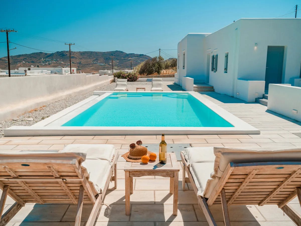 a-pool-and-chairs-on-a-deck-mykonos-travel-guide