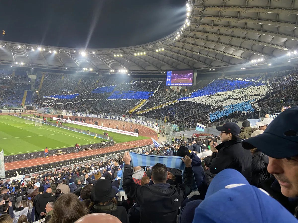 A picture of people sitting in a stadium watching a football game.