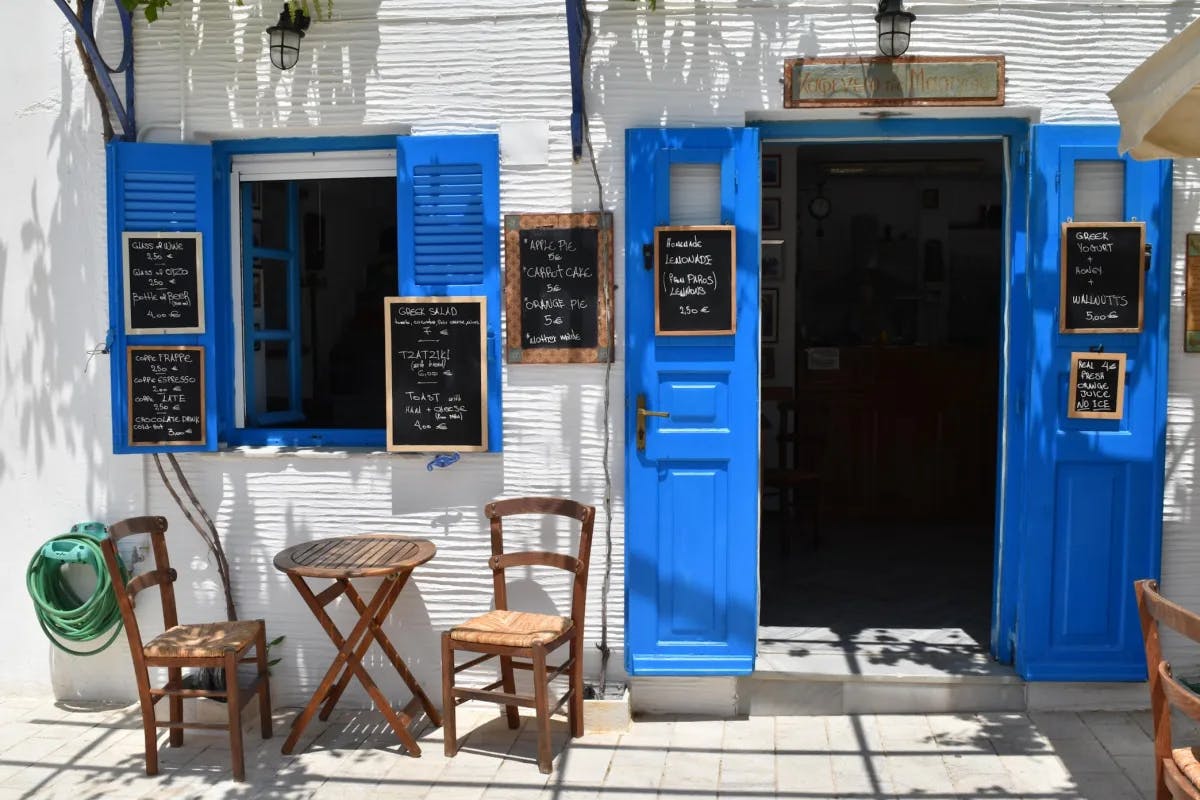 A picture of the exterior of a restaurant with blue doors and windows.