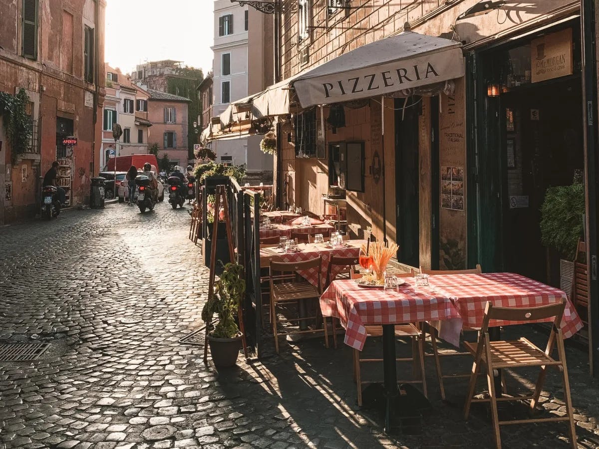 Outdoor sitting of a restaurant saying Pizzeria.