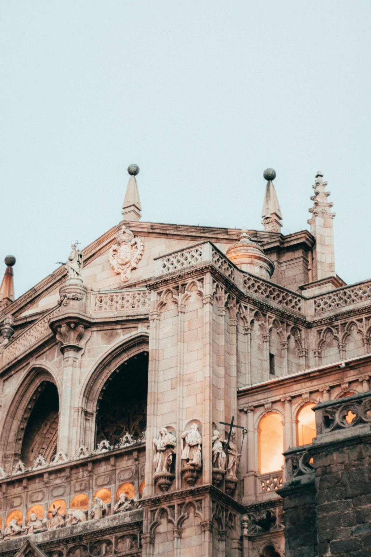 A close up shot of a traditional, stone Parador in Spain, with intricate carvings in the architecture. 