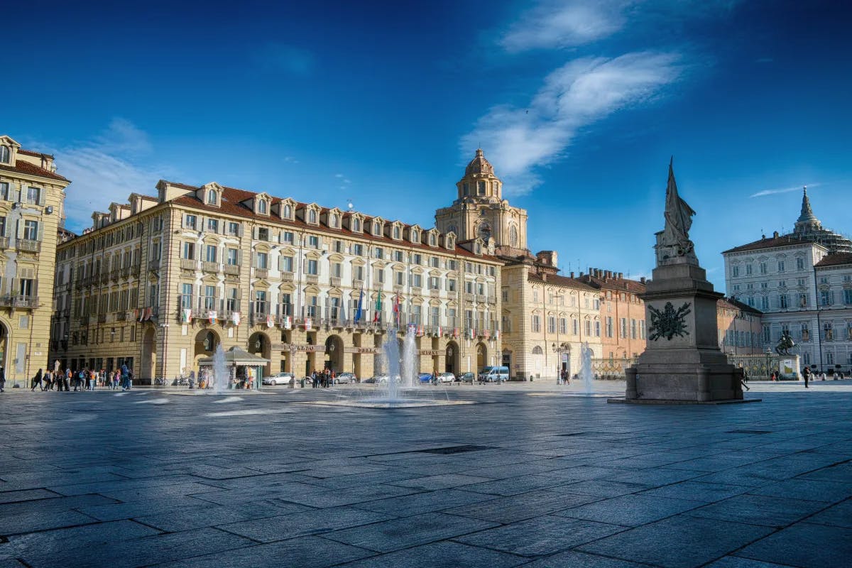 A view of a beige concrete palace with a statue in front of it