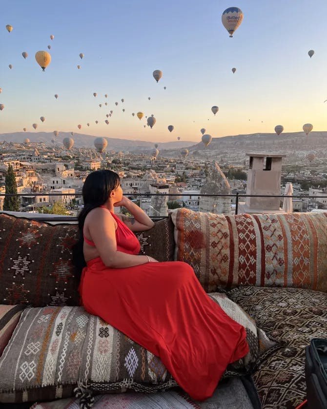 Picture of Mia in red dress watching hot air ballon