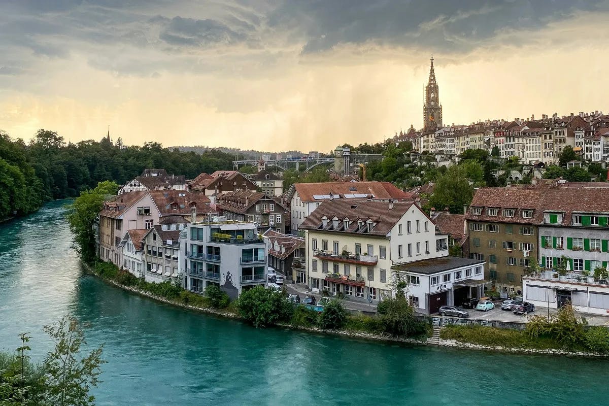 An aerial view of quaint restaurants and buildings along the river bank in Bern