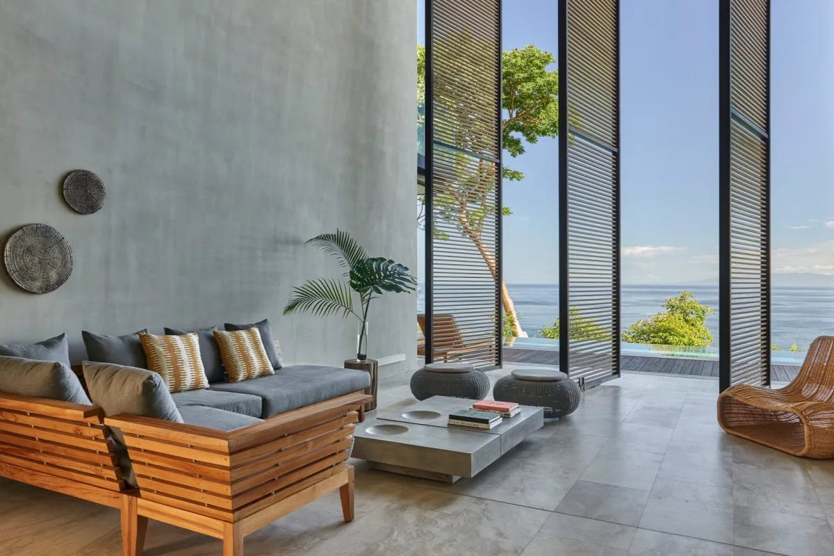 Loungers and sleek decor are positioned along an outdoor common space with excellent views of the beach and Pacific