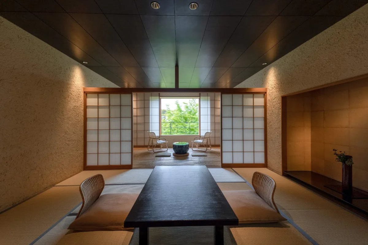 a traditional Japanese dining room with a low table and wooden furniture